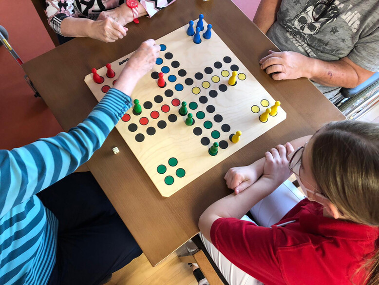 Würfeln oder das Bewegen der kleinen Hütchen fordern die Motorik. Antoniushaus der Kreuzschwestern in Feldkirch, Spielenachmittag
